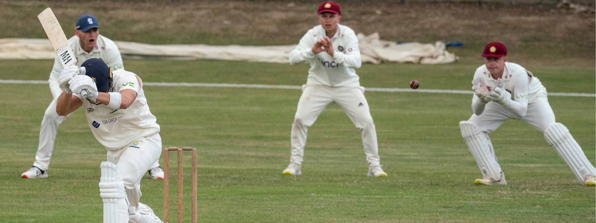 Cricket players attempting to catch a ball