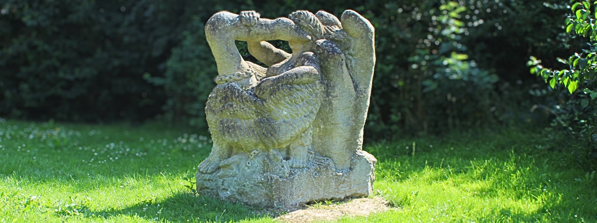 an almost square rock with a swan and person carved into it