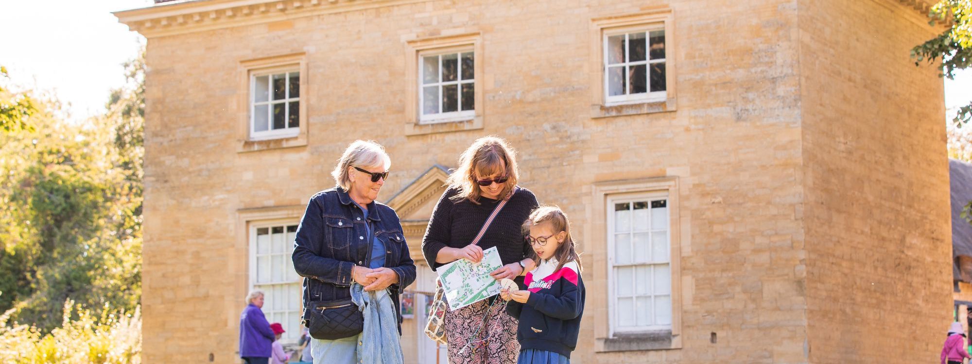 Family looking at event programme at Great Linford Manor Park in Milton Keynes