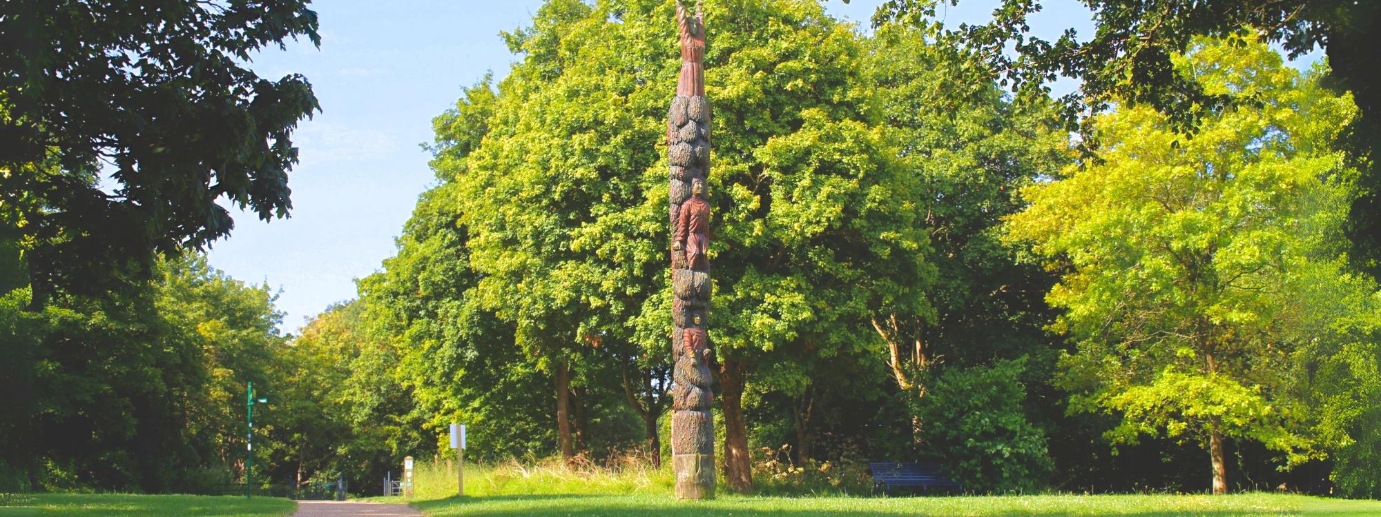 a tall vertical pole made of wood with figure's carved into its wood