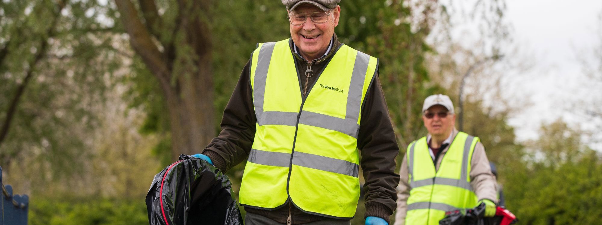 Person litter picking holding bin bag