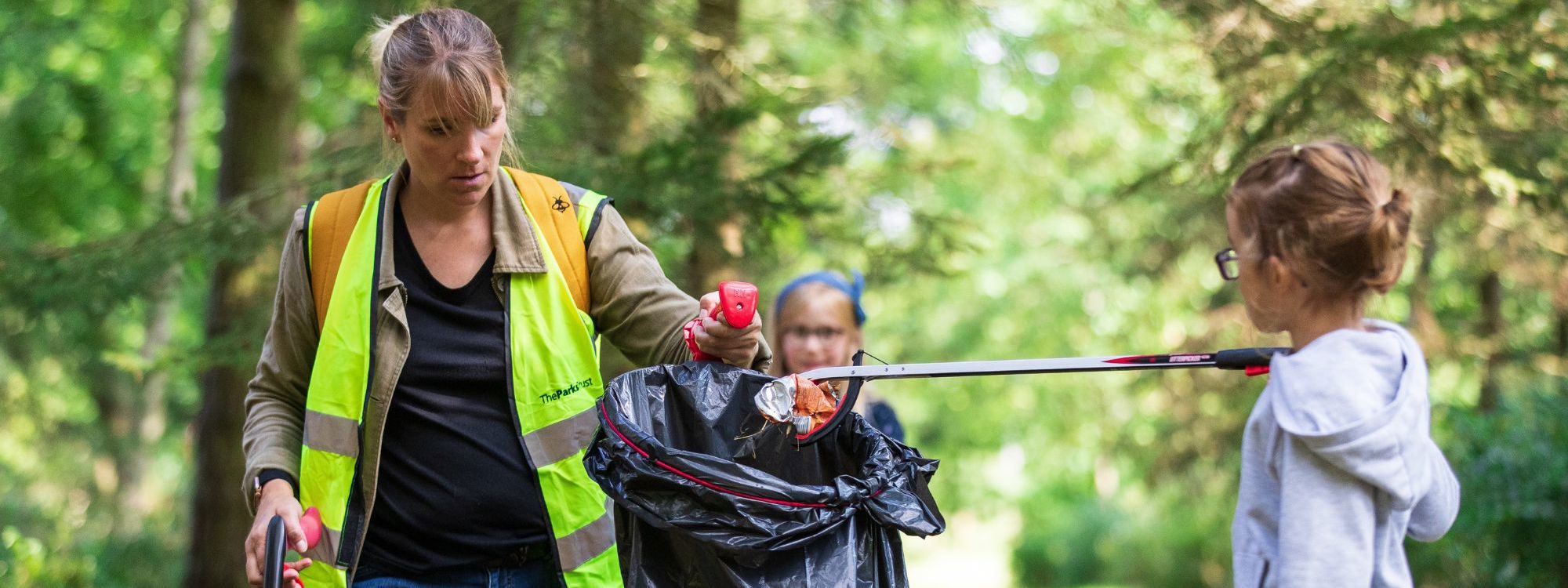 Family litter picking in a park