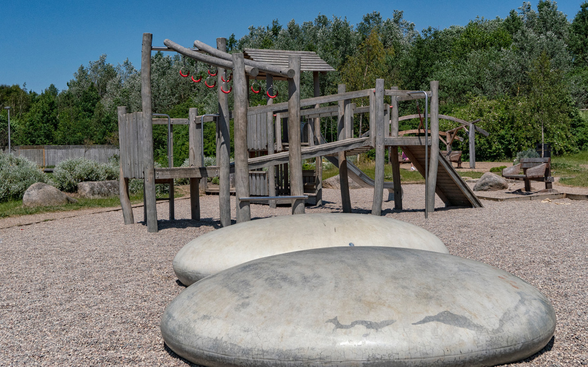 Play equipment with large pebbles in foreground.