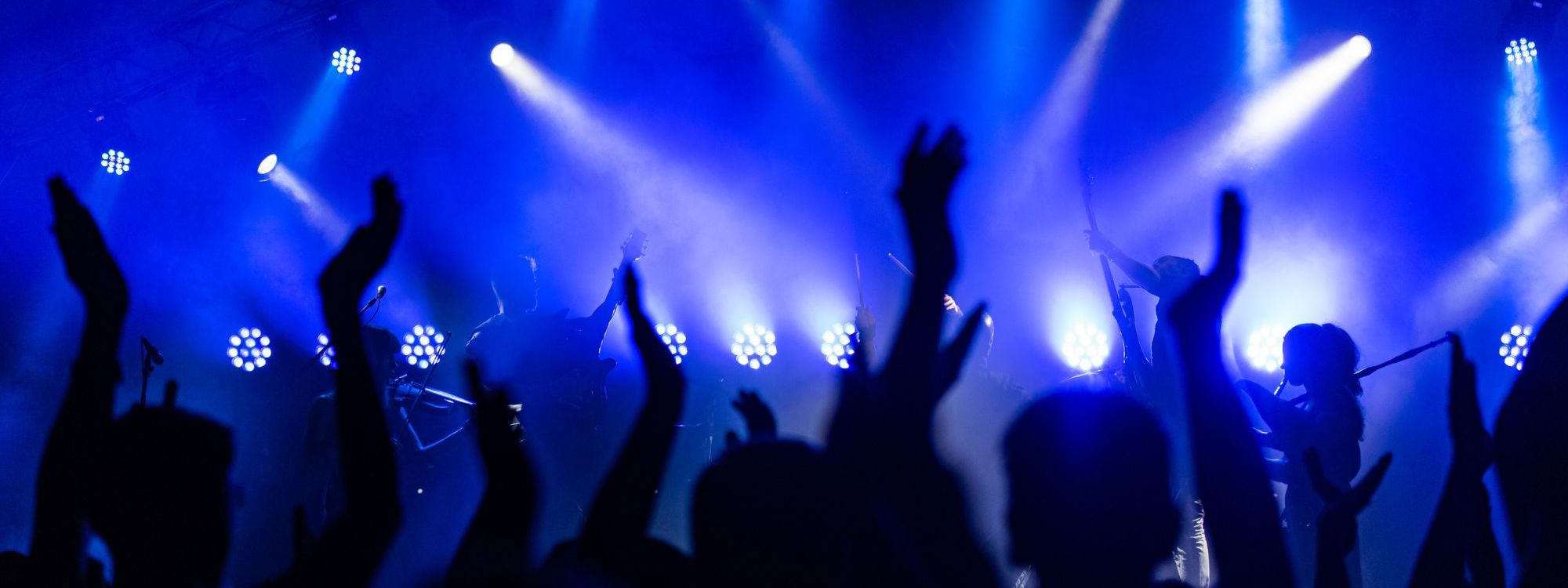 People with their hands up dancing at music event