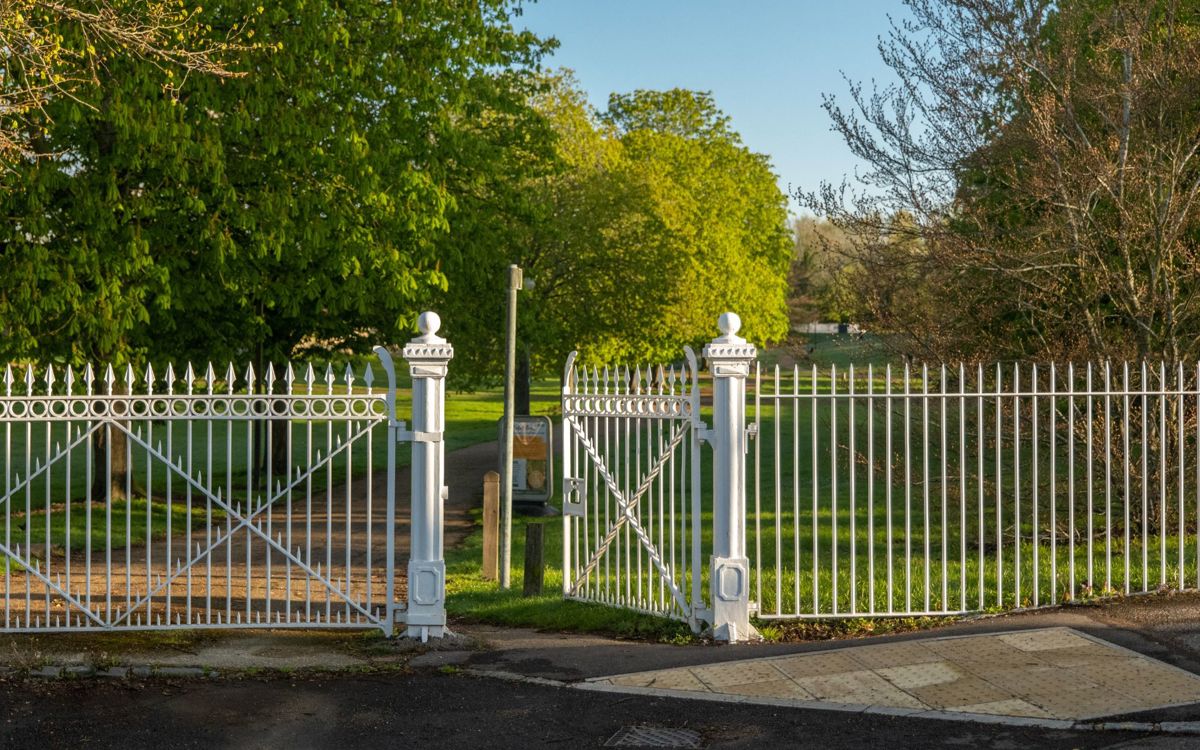 White metal gate and fences outside Great Linford Manor Park