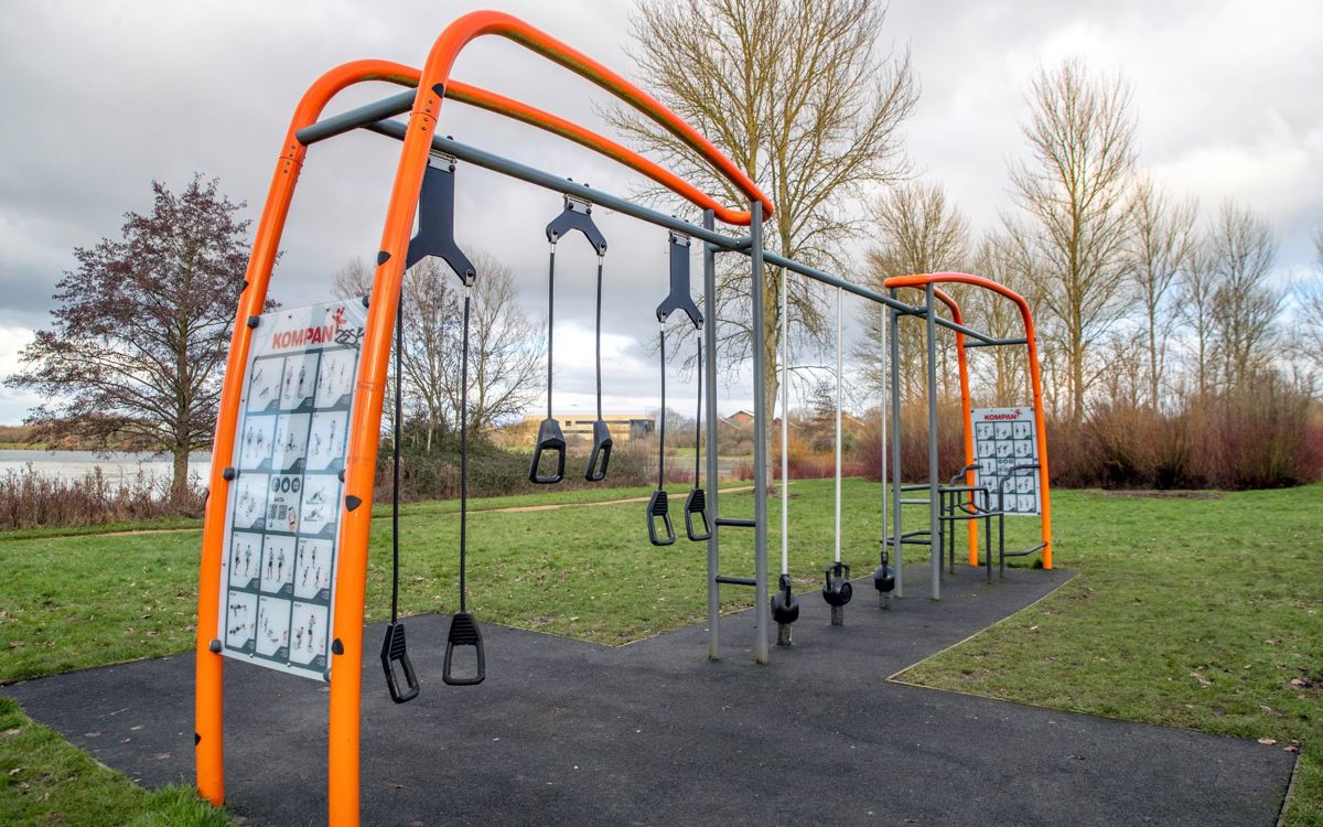Orange outdoor gym equipment with weights next to Willen Lake
