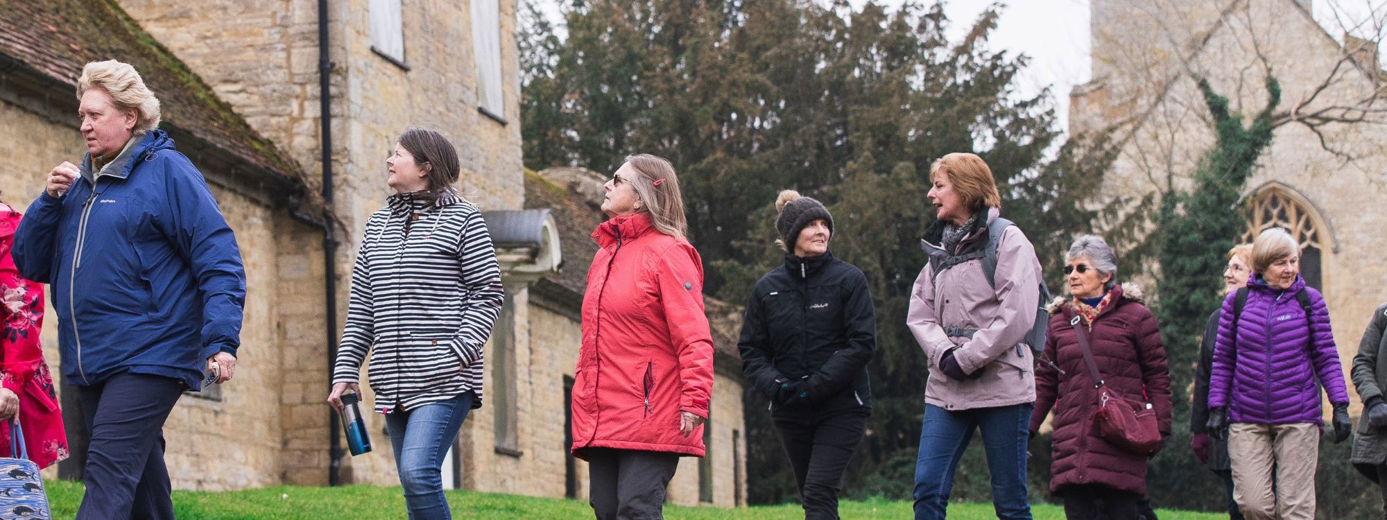 Group walking in front of Almhouses at Great Linford Manor Park