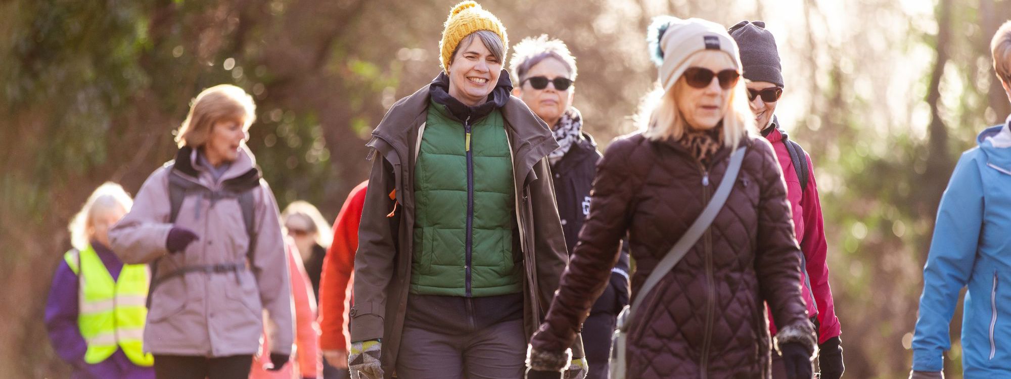 Women in jackets and hats walking in the park