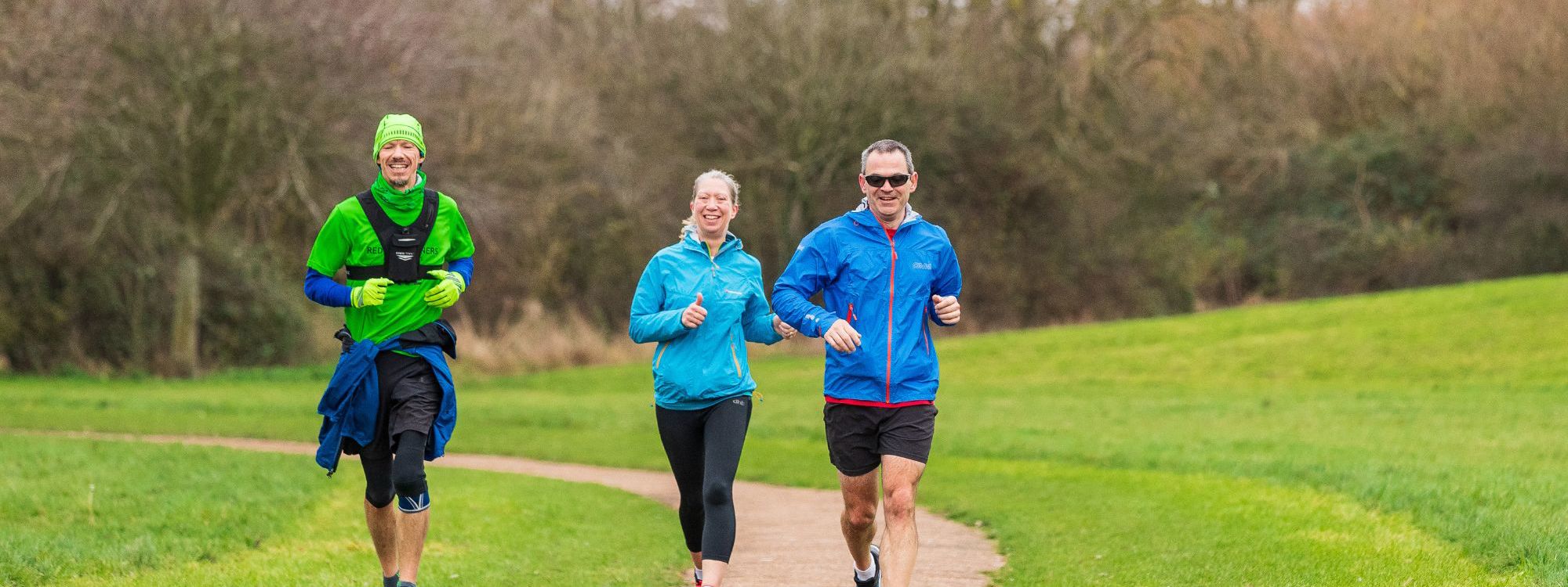 Group of runners going down a path in the park