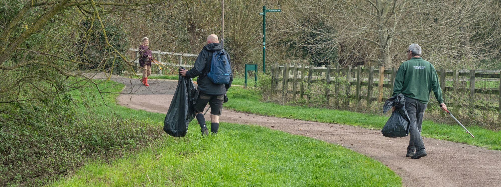 Two Litter Cleansing Officers litter picking along river valley