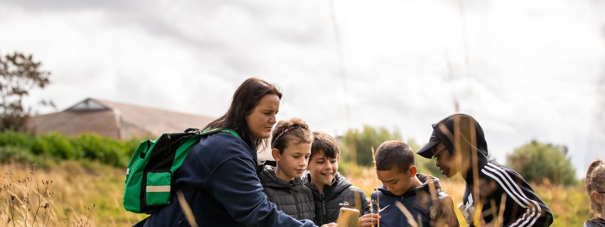 Teacher leading session with children in park