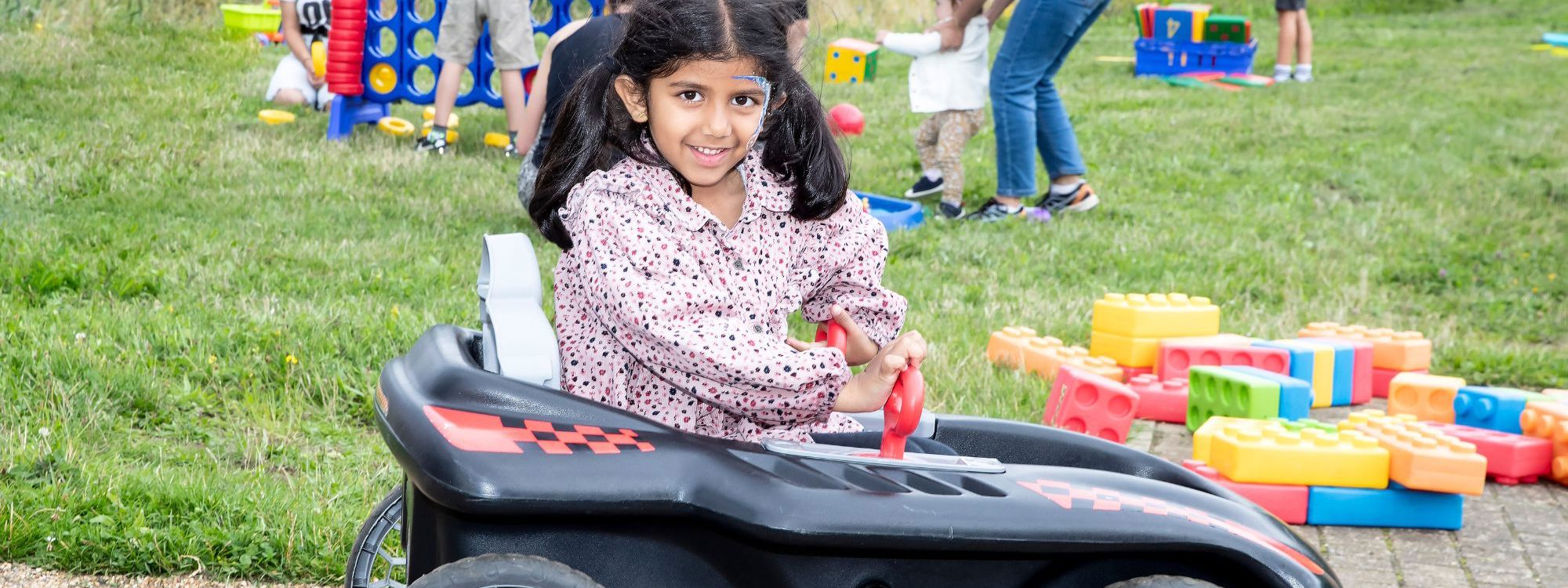 Child in toy car at Parkland Play event